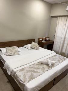 a bedroom with a large bed with white sheets and pillows at Pinaki Comfort Stay, Vile Parle in Mumbai