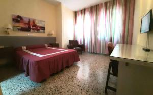 a hotel room with a bed and a table at Hotel Paraíso in Lanjarón