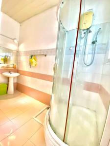 La salle de bains est pourvue d'une douche et d'un lavabo. dans l'établissement Gem Villa 67, biệt thự 15 phòng có hồ bơi lớn, à Hô-Chi-Minh-Ville
