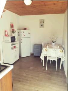 een keuken met een tafel en een witte koelkast bij La Gallizza in Cefalù