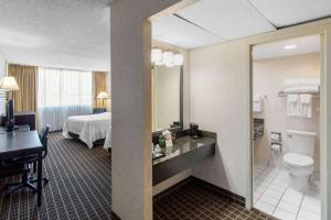 a hotel room with a toilet and a sink at Clarion Hotel Denver Central in Denver