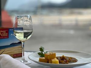 a plate of food next to a glass of wine at Playa Y Cañas in Noja