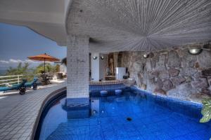 a swimming pool in a resort with a stone wall at Villa Azul in Puerto Vallarta