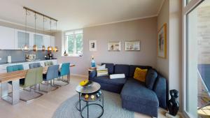 - un salon avec un canapé bleu et une table dans l'établissement Eichenhain Wohnung 07, à Pelzerhaken