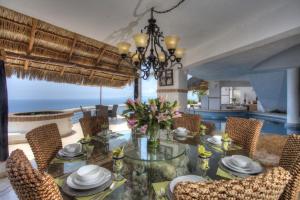 a dining room with a glass table and chairs at Villa Azul in Puerto Vallarta