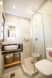 a bathroom with a shower and a sink and a toilet at Hovolo Hotel Apartments in Neo Klima