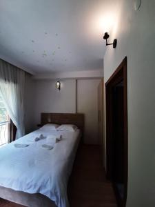 een slaapkamer met een groot wit bed en handdoeken bij Elegant Residence in Çamlıhemşin