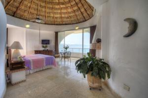 a bedroom with a bed and a view of the ocean at Villa Azul in Puerto Vallarta