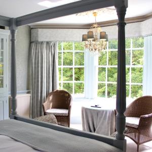 a bedroom with a bed with a table and chairs at Rafters at Riverside House Hotel in Bakewell