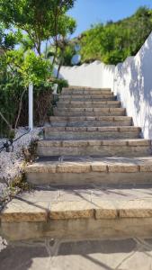 a set of stone stairs next to a body of water at casa l'Ulivariu affittacamere in San Teodoro