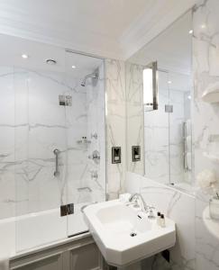a bathroom with a sink, toilet and bathtub at The Athenaeum Hotel & Residences in London