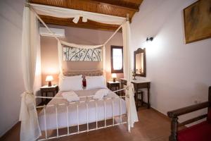 a bedroom with a canopy bed in a room at Hovolo Hotel Apartments in Neo Klima