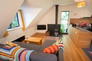 a living room with a couch and a kitchen at The Loft at Ash Beacon - Gorgeous 2 bed, hideaway in lovely private grounds in Axminster