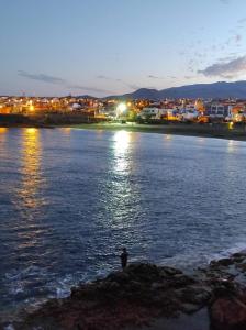 une personne debout sur un rocher dans l'eau la nuit dans l'établissement Apartamento Cueva de los Mil Colores, à La Garita