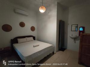 a small bedroom with a bed and a sink at H.Said Homestay in Gili Trawangan