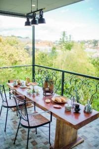 a wooden table and chairs on a balcony at Dalat Terrasse Des Roses Villa in Da Lat