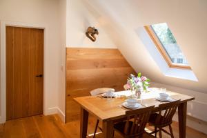 a dining room with a wooden table and a window at The Loft at Ash Beacon - Gorgeous 2 bed, hideaway in lovely private grounds in Axminster
