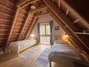 a attic room with two beds and a window at Viscri 32 - White Barn and Blue House in Viscri