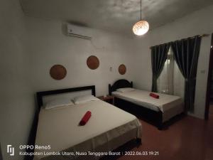 a bedroom with two beds with red cards on them at H.Said Homestay in Gili Trawangan