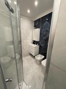 a bathroom with a toilet and a glass shower at Bnb apartment Ferrara in Udine