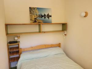 een slaapkamer met een bed en planken aan de muur bij APPARTEMENT MONTAGNE in Réallon
