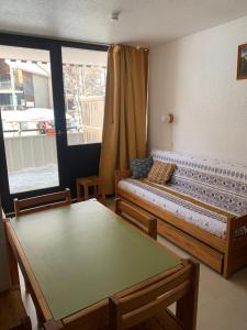 a room with a bed and a table and a window at APPARTEMENT MONTAGNE in Réallon