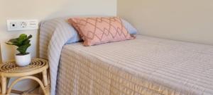 1 cama con almohada rosa y mesa auxiliar en APARTAMENTO CAMP DE MORVEDRE, en Castellón de la Plana 12 fotos más
