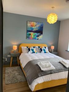 a bedroom with a bed with a blue wall at Natures Rest Apartment in Doolin