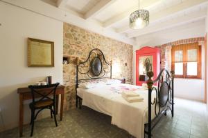 a bedroom with a bed and a table and a chair at Casa Il giuggiolo in Giuncarico