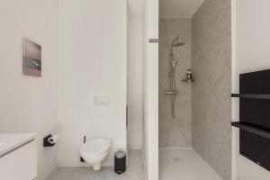 a white bathroom with a toilet and a shower at Suite city center in quiet street & airco in Antwerp