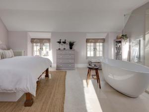 een slaapkamer met een groot bed en een bad bij Stow House in Stow on the Wold
