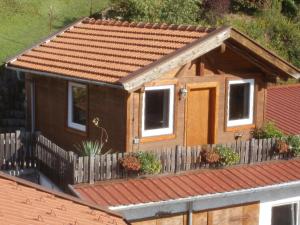 ein kleines Haus mit einem Holzzaun davor in der Unterkunft Ferienwohnung Weiherwiesel in Bodenmais