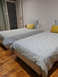 dos camas sentadas una al lado de la otra en una habitación en Le Cocon d'Hanna, en Bagnols-sur-Cèze