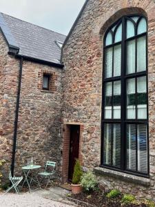 a brick building with a table and chairs in front of it at 4 Torwood Gables. The Old Victorian School House in Torquay