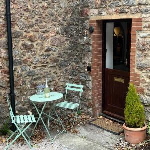 a table and chairs in front of a stone building at 4 Torwood Gables. The Old Victorian School House in Torquay