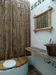 a bathroom with a toilet and a bamboo shower curtain at INZU Lodge in Gisenyi