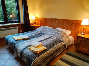 a bedroom with a bed with towels on it at Apartamenty Kotwica in Poddąbie