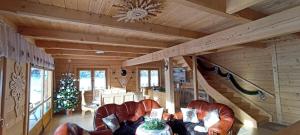 a living room with leather chairs and a christmas tree at Gościniec Dziubasowki in Nowy Targ