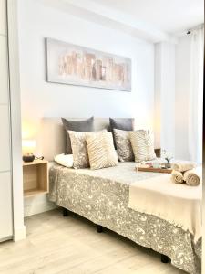 - une chambre blanche avec un lit et des oreillers dans l'établissement Nuevo Apto D Centrico Terraza Garaje Incluido, à Castro Urdiales