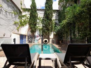コンスエグラにあるホテル ルーラル ラ ビダ デ アンテスのスイミングプール(椅子2脚、噴水付)
