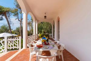 een witte tafel en stoelen op een patio bij Villa Garden Rose by BarbarHouse in Porto Cesareo