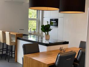 a kitchen with a wooden table and black counter top at De Wellnessloft Bocholt in Bocholt