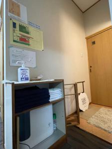 una habitación con un estante con toallas y una puerta en すずめのお宿 セキレイの間 最大5名 Wagtail Room Maximum of 5 people, en Kotohira