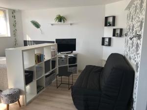 a living room with a couch and a desk at Le Clémenceau in Péronne