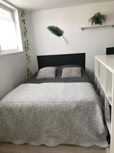 a bedroom with a bed with a gray comforter at Le Clémenceau in Péronne