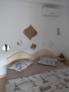Dormitorio con cama con posters en la pared en Appartement 1ch Romantique Vue sur Piscine, en Nabeul