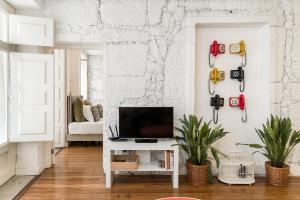 salon z telewizorem i białą ścianą w obiekcie Rua de Trás Apartments w Porto