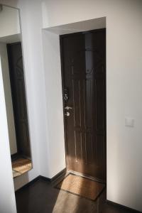 a hallway with a brown door and a mirror at Meretskova Apartment in Velikiy Novgorod