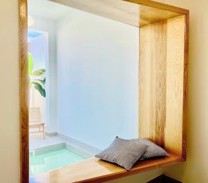 un espejo sentado en un estante de madera junto a una piscina en Canaryislandshost l Boya Suites, en Playa Honda