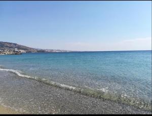 a beach with blue water and a rocky shoreline at Home Ciccilla in Reggio di Calabria
